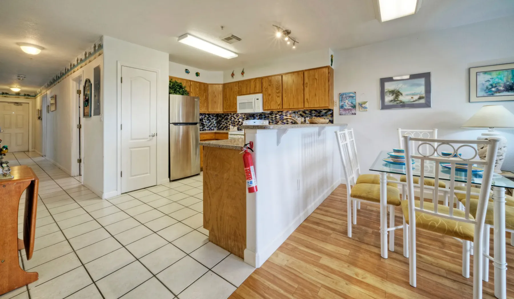 Cocina y comedor abiertos con una barra y una mesa.