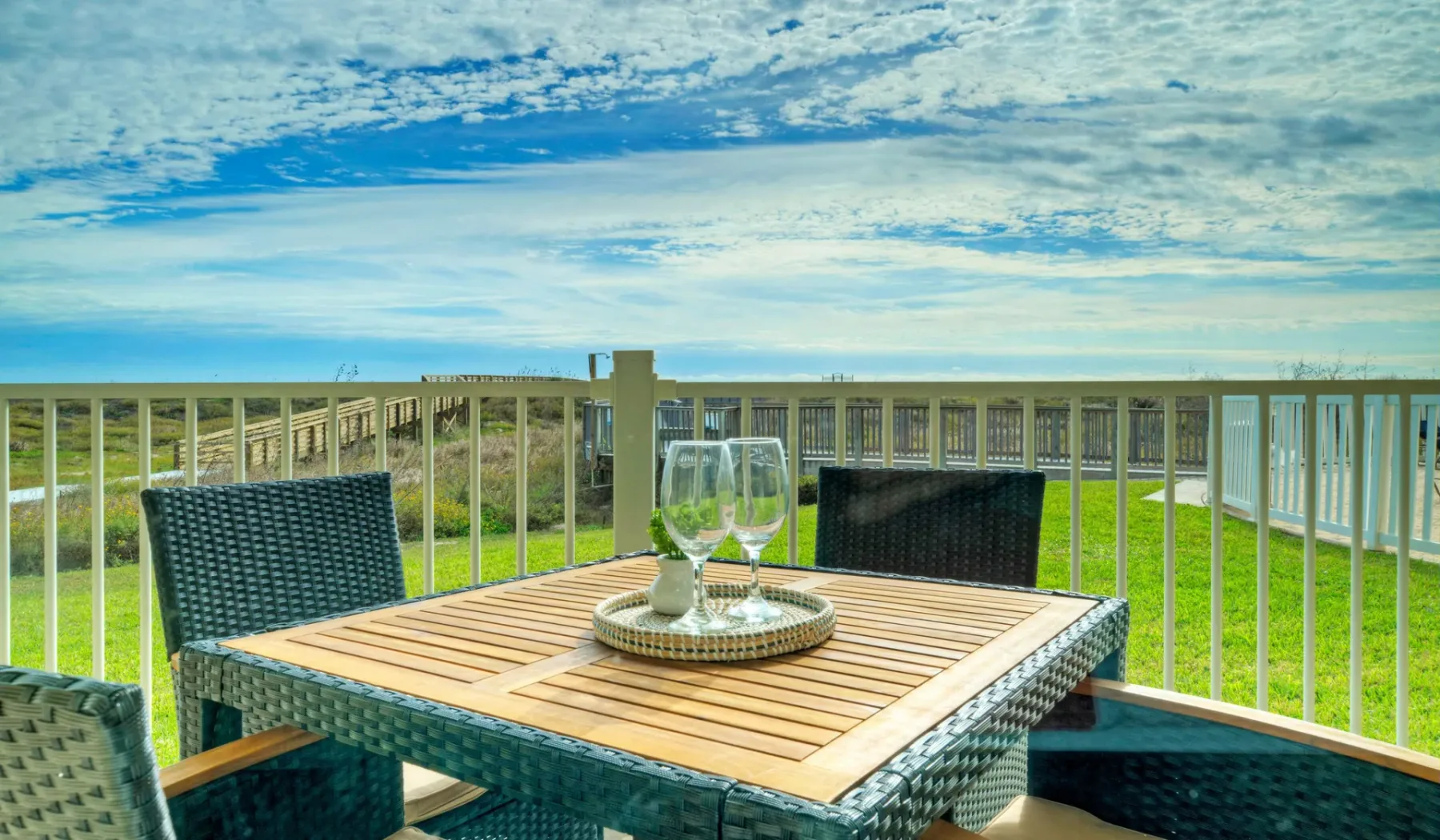 Una mesa de comedor y asientos al aire libre dan a un paisaje verde.