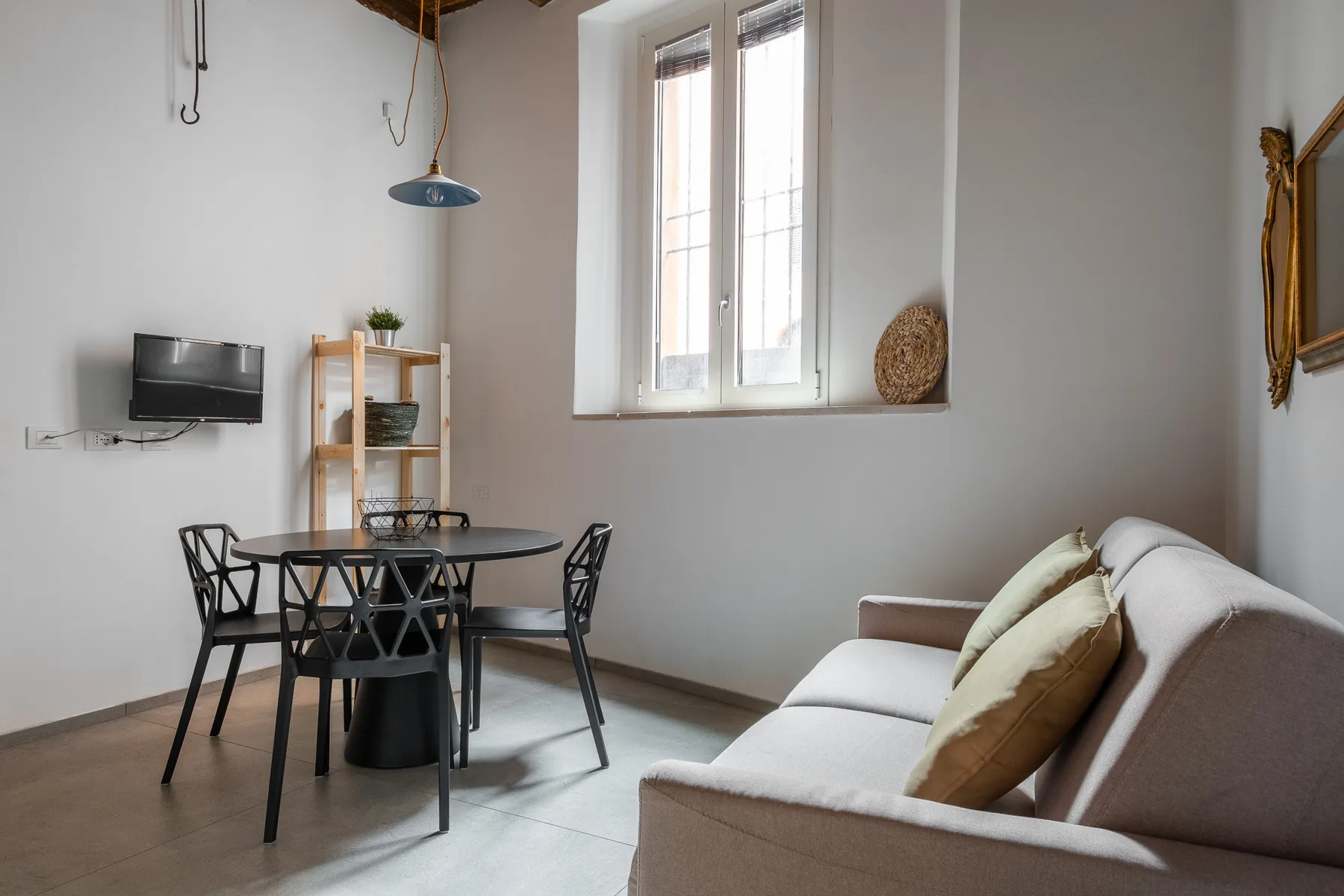 Una sala de estar y comedor con asientos, una mesa y una ventana.