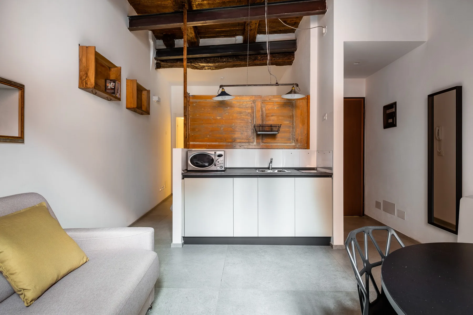 Una cocina compacta con zona de comedor, una barra, lámparas colgantes y asientos.