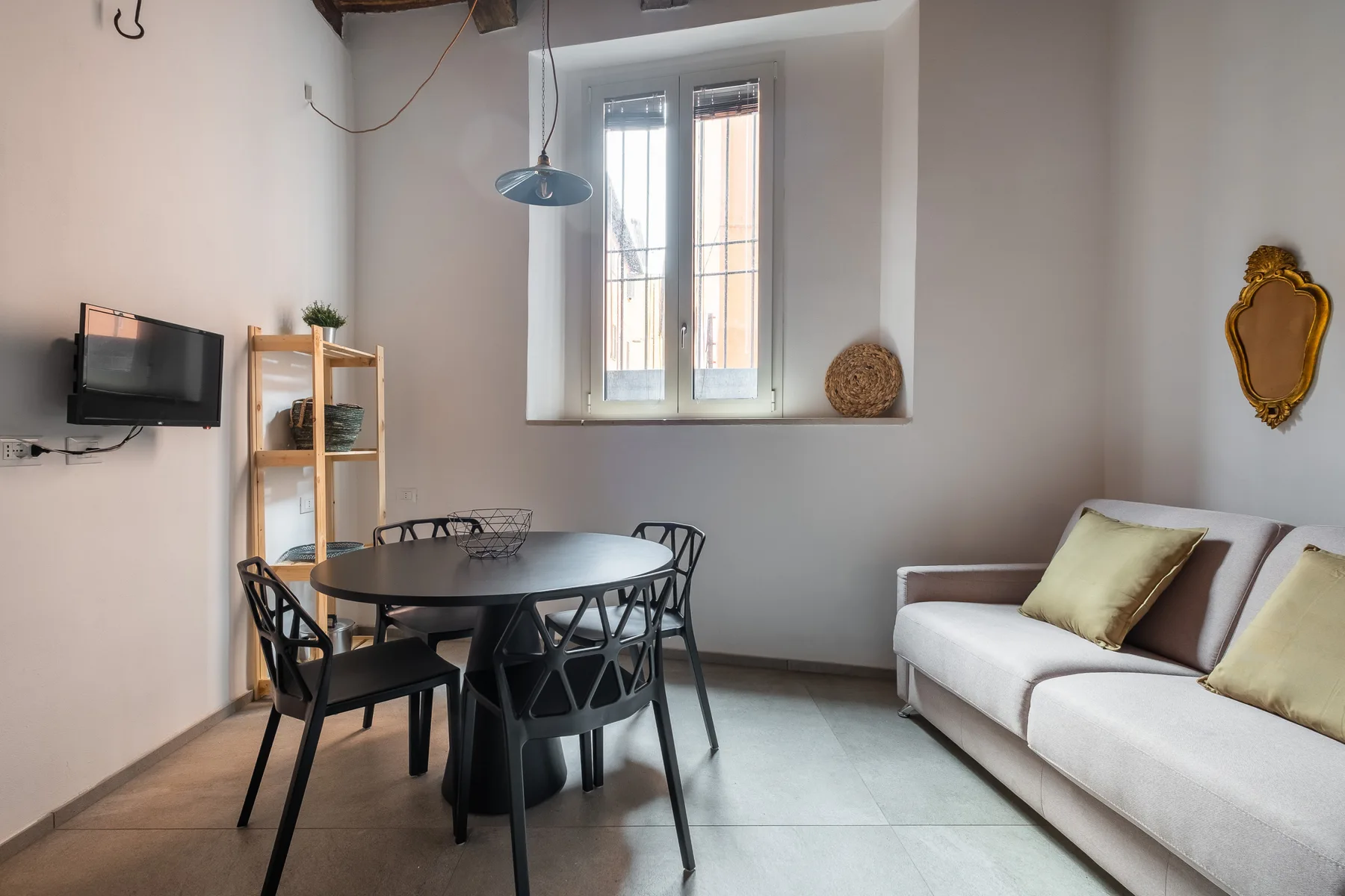 Una zona de comedor y estar con una mesa, asientos y una ventana.