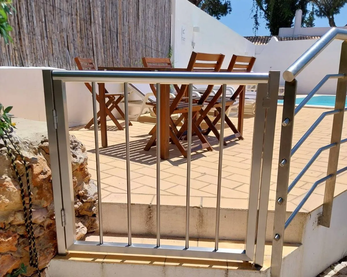 Una zona de comedor al aire libre con asientos de madera está junto a una piscina.