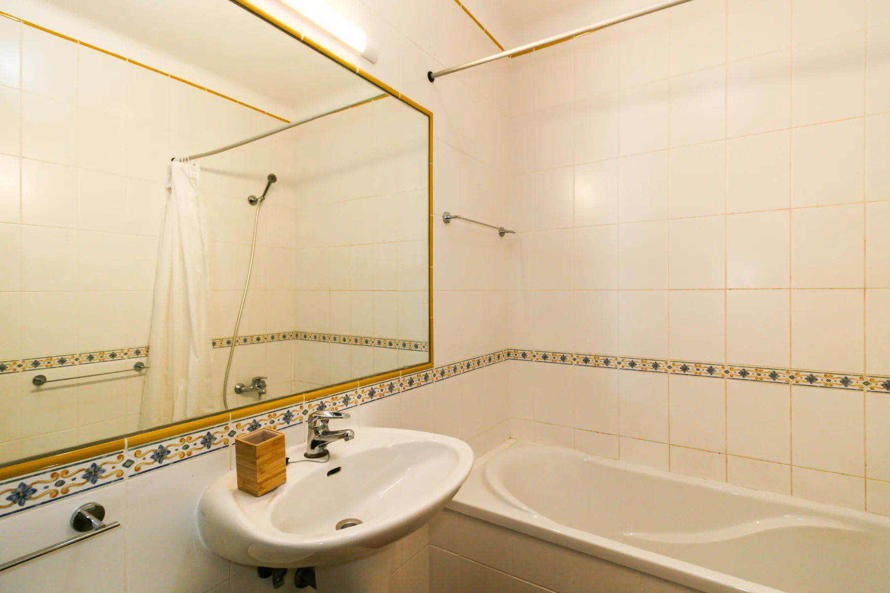 A tiled bathroom with a sink and bathtub.