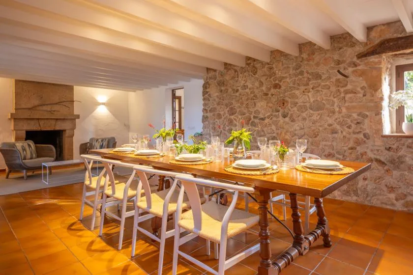 A dining room with a long table set with plates and glassware.