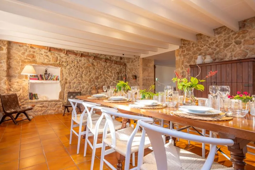 A dining room with a long table set with plates and glassware.