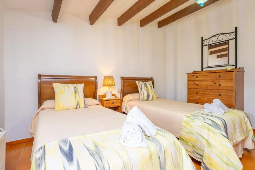 A bedroom with two beds and a wooden dresser.
