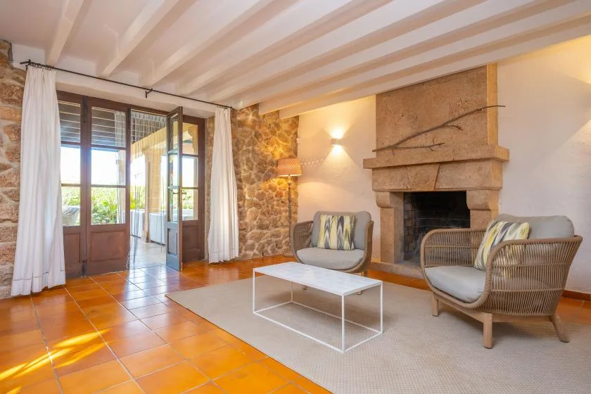 A living room with a stone fireplace, seating, and a coffee table.