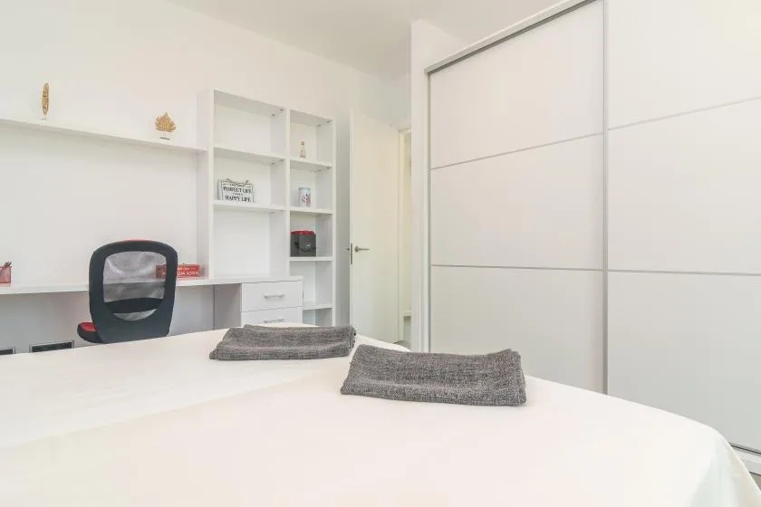 Bedroom with a bed, desk, and built-in shelving.