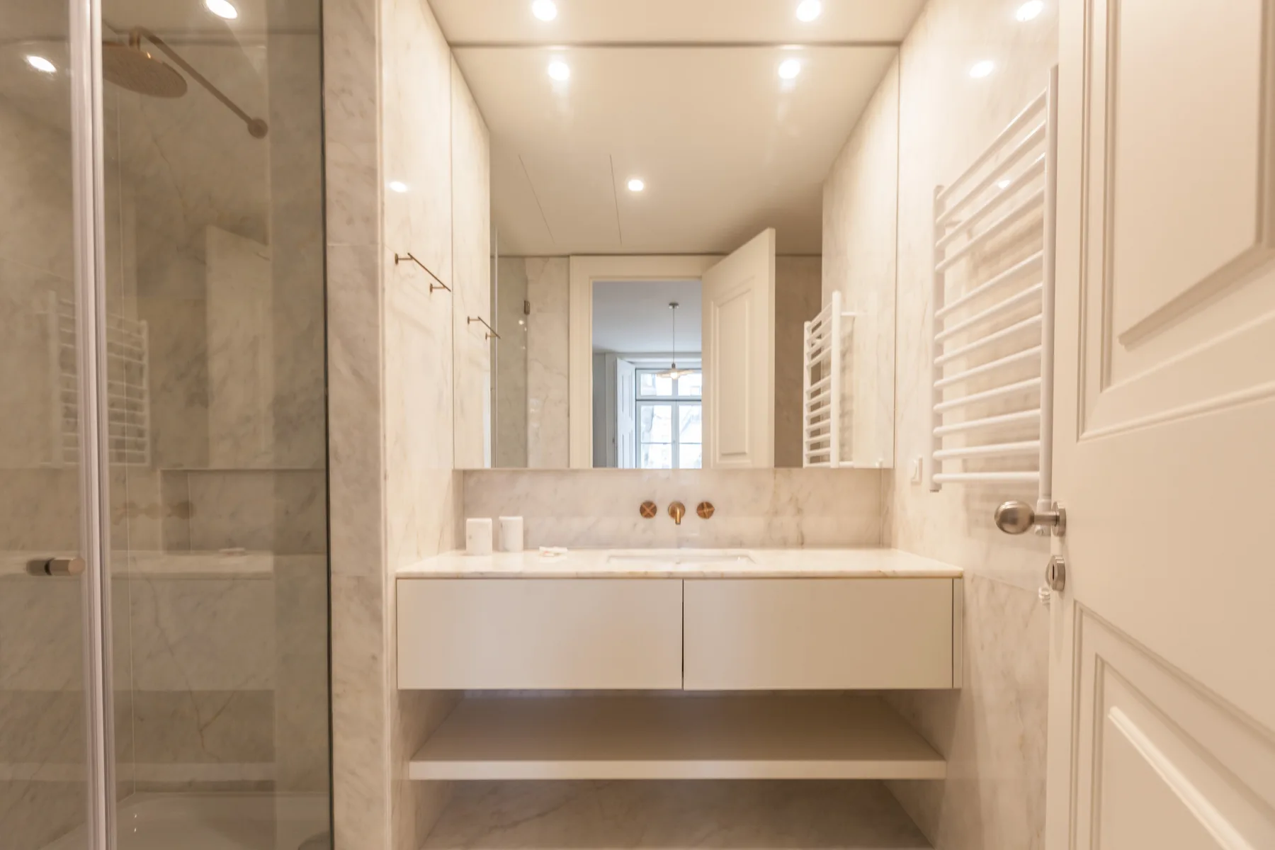 Un baño luminoso con un lavabo amplio y una ducha de cristal.