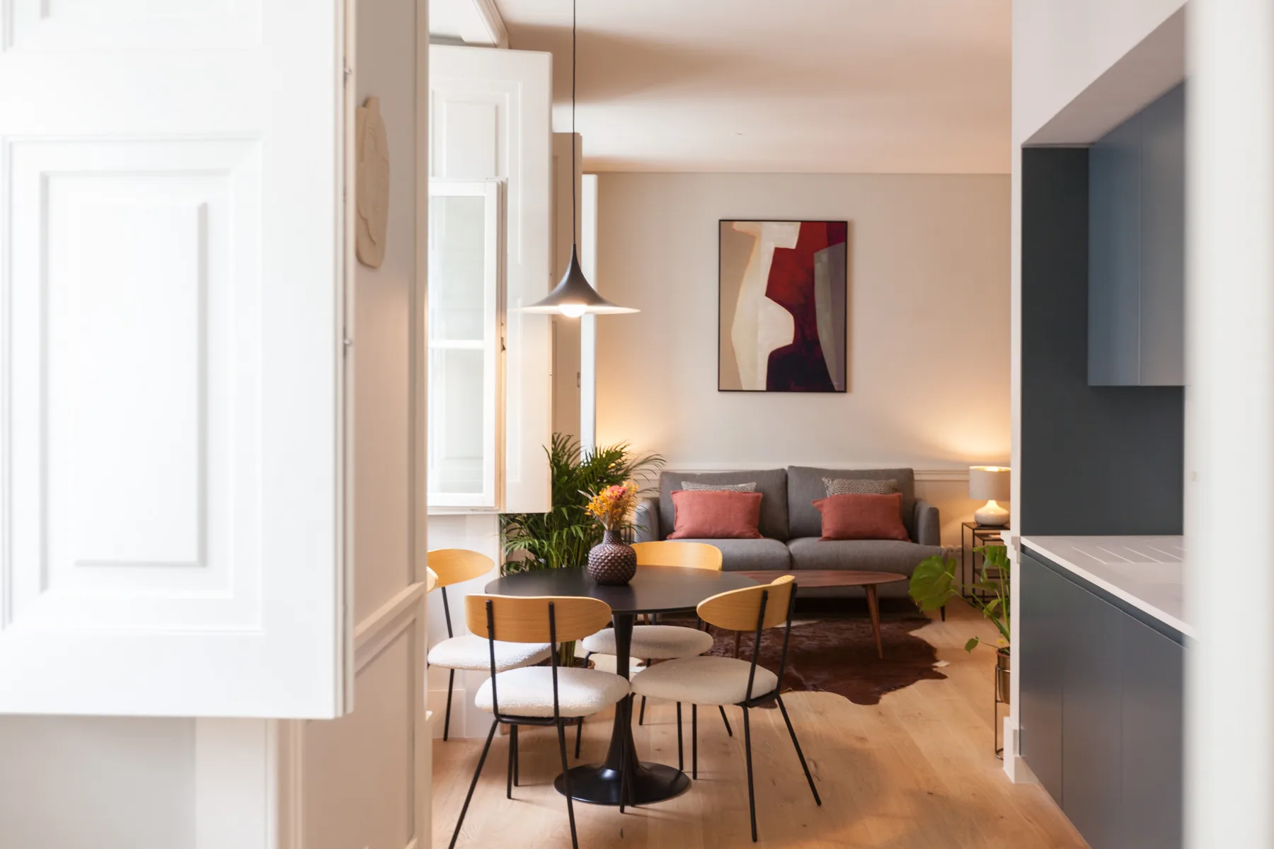 Sala de estar con zona de asientos, mesa de centro y una obra enmarcada.