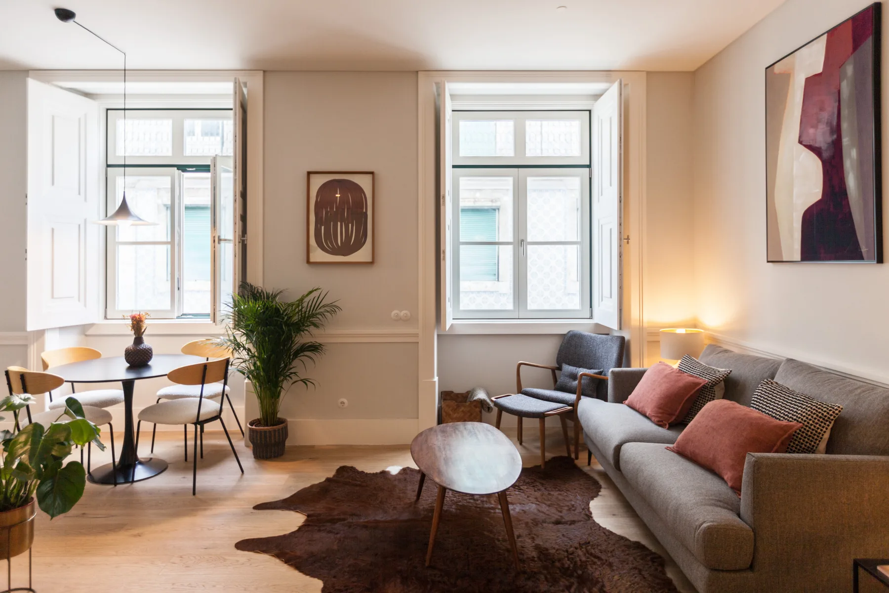 Una luminosa sala de estar con sofá, mesa de centro y zona de comedor.
