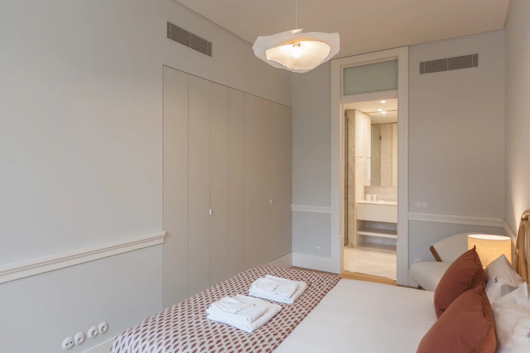 Dormitorio con una cama y una puerta abierta hacia el baño.