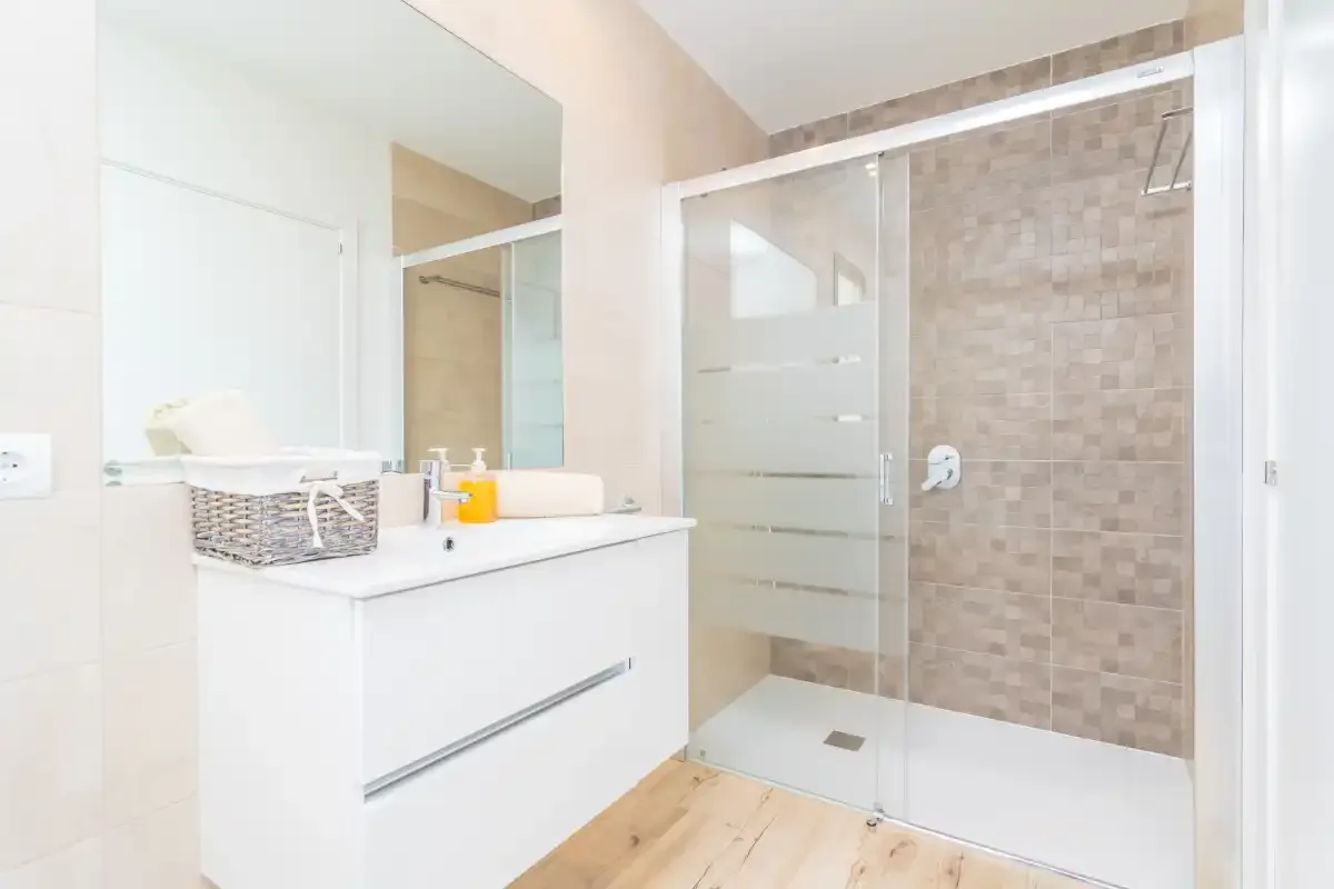 A bright bathroom with a vanity and glass shower.