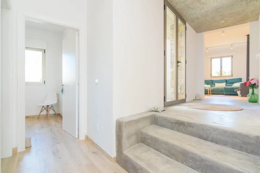 A bright interior hallway opens onto a raised sitting area with a sofa.