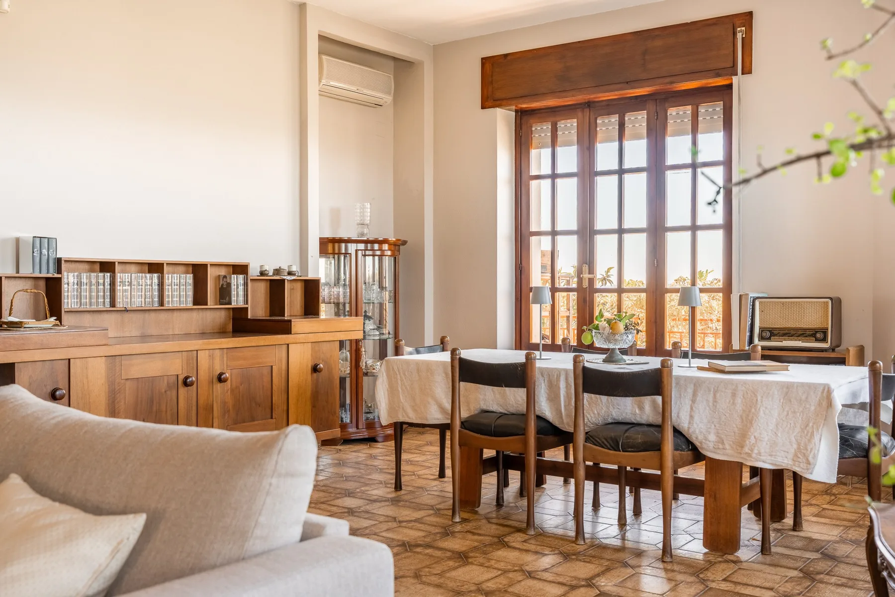 Comedor con una mesa larga junto a una ventana grande.