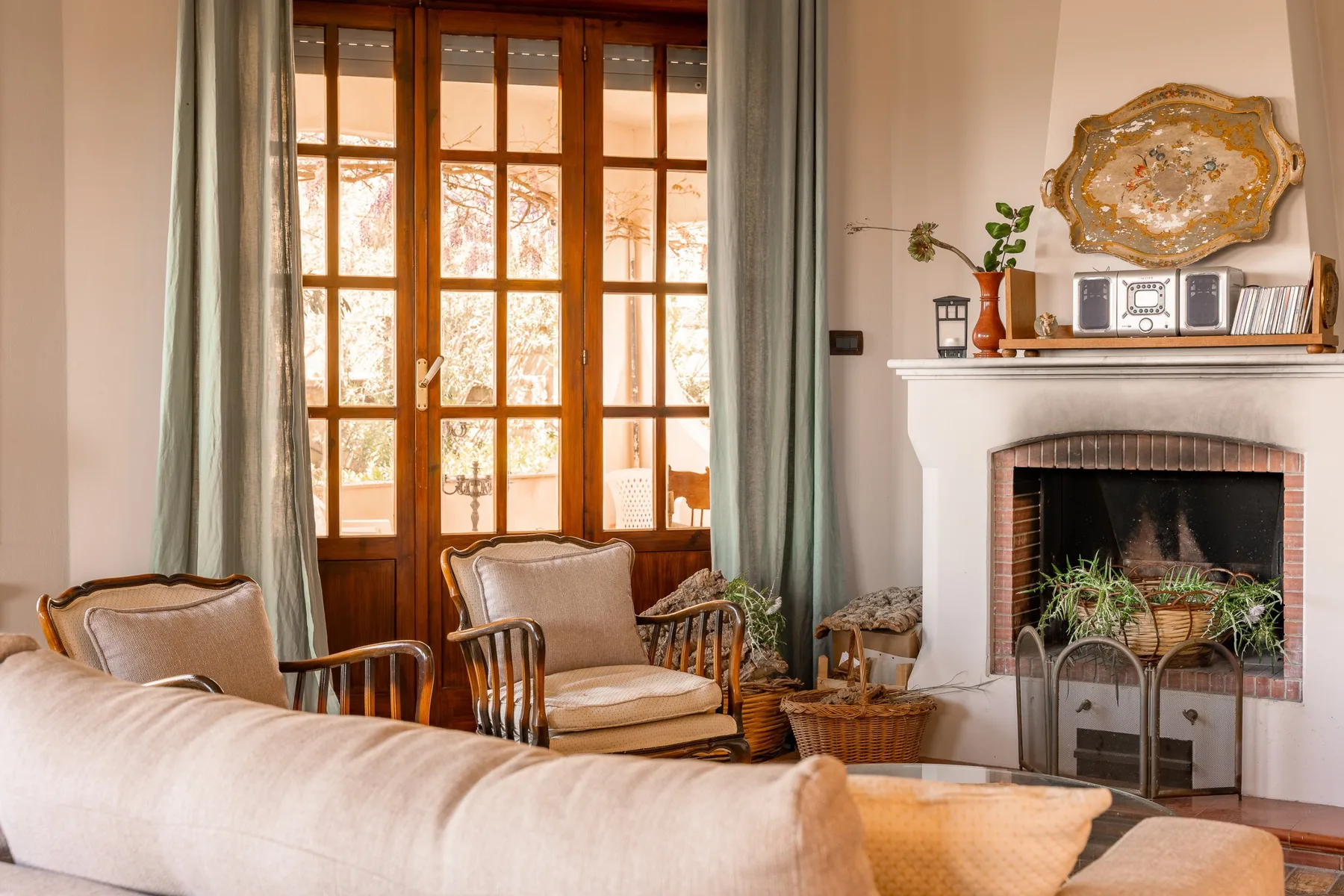 A living room with seating, a fireplace, and tall windows.