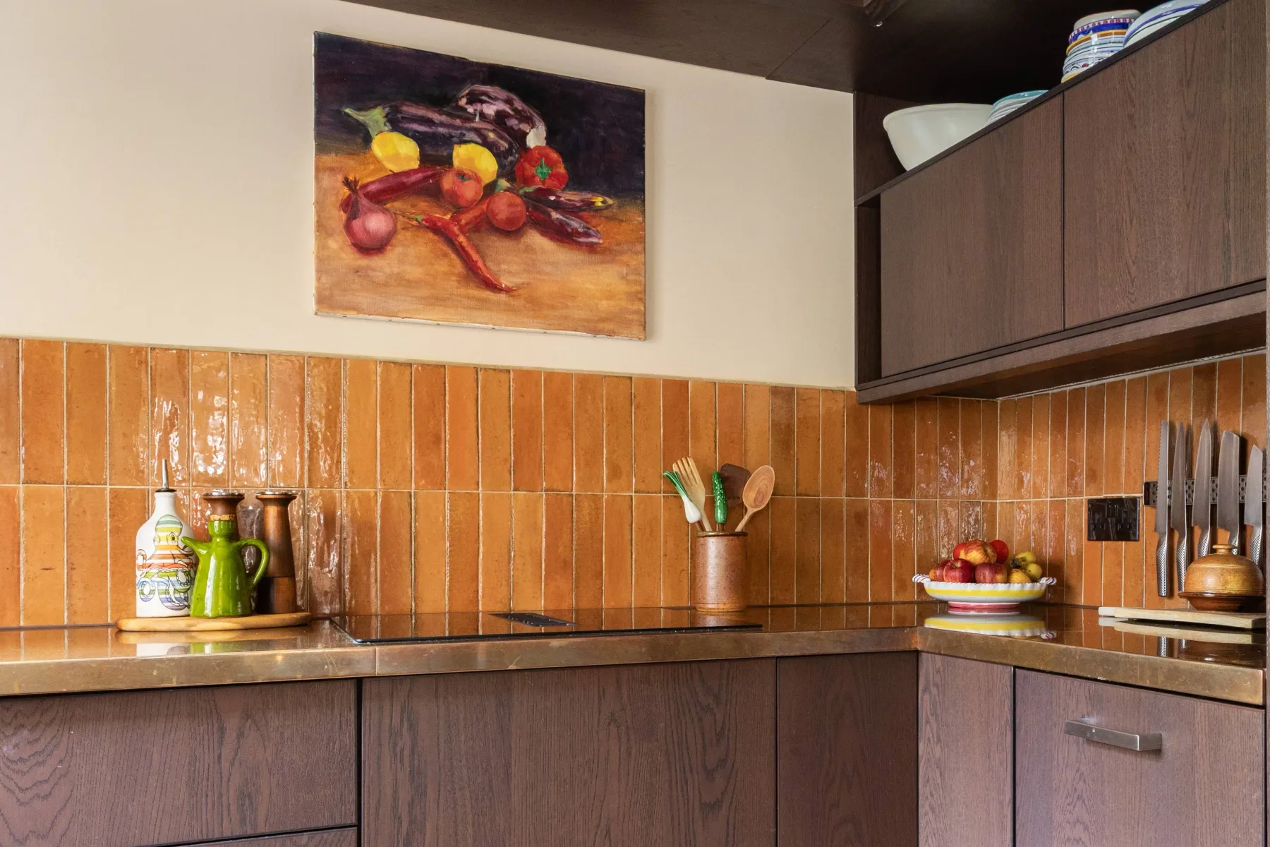 A kitchen with wooden cabinets, tiled walls, and a countertop.