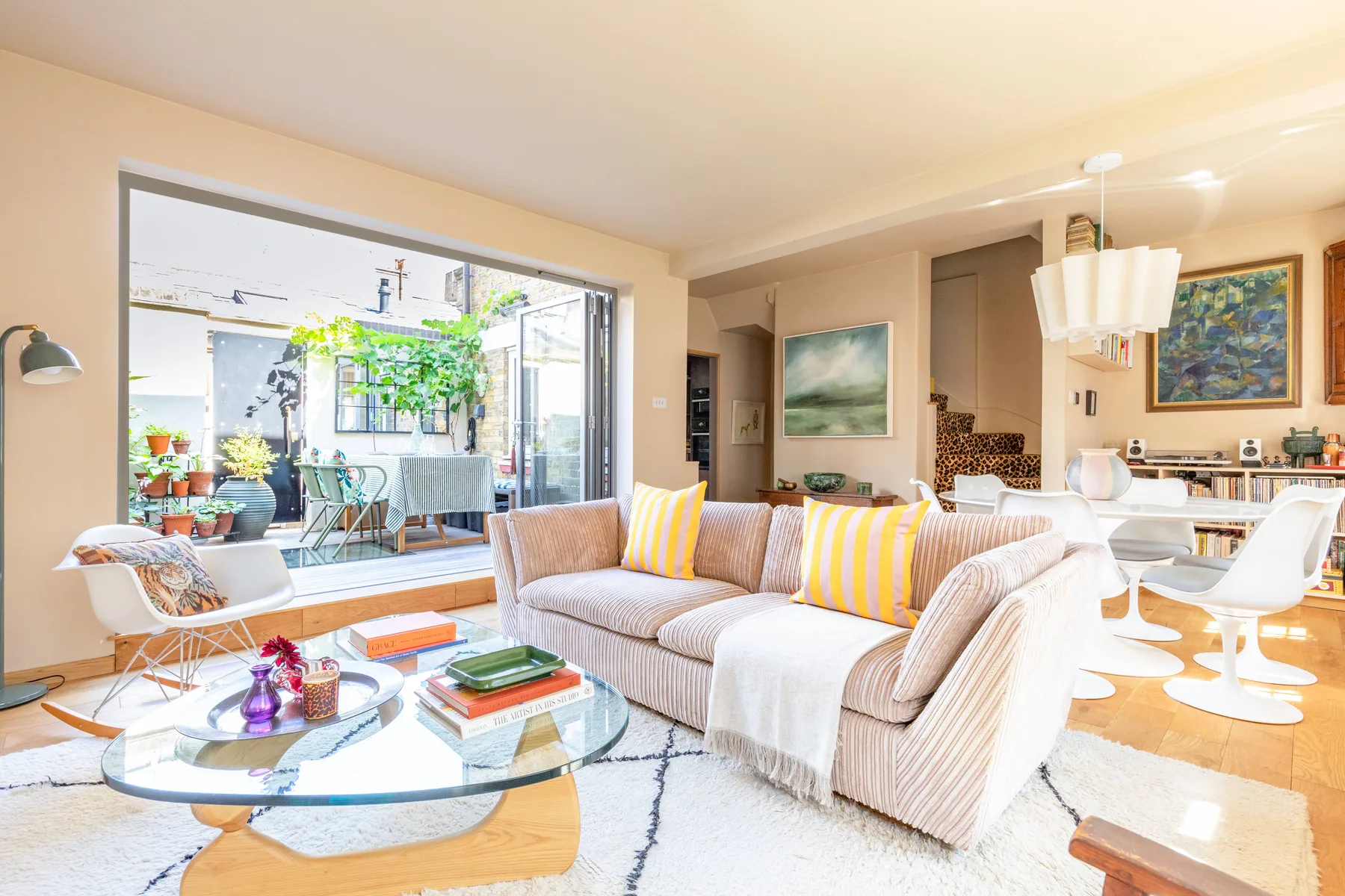 A bright living room with a sectional seating area beside a dining space.