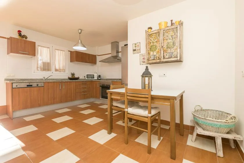 A kitchen and dining area with wooden cabinets and a table.