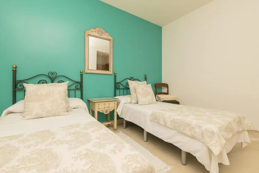 A bedroom with two beds and a mirror on the wall.