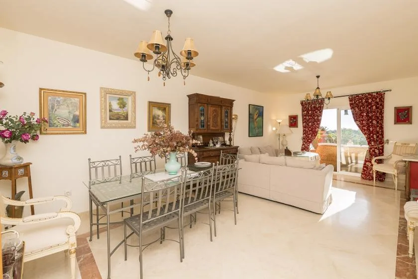 A bright living and dining room with a dining table and seating near the window.