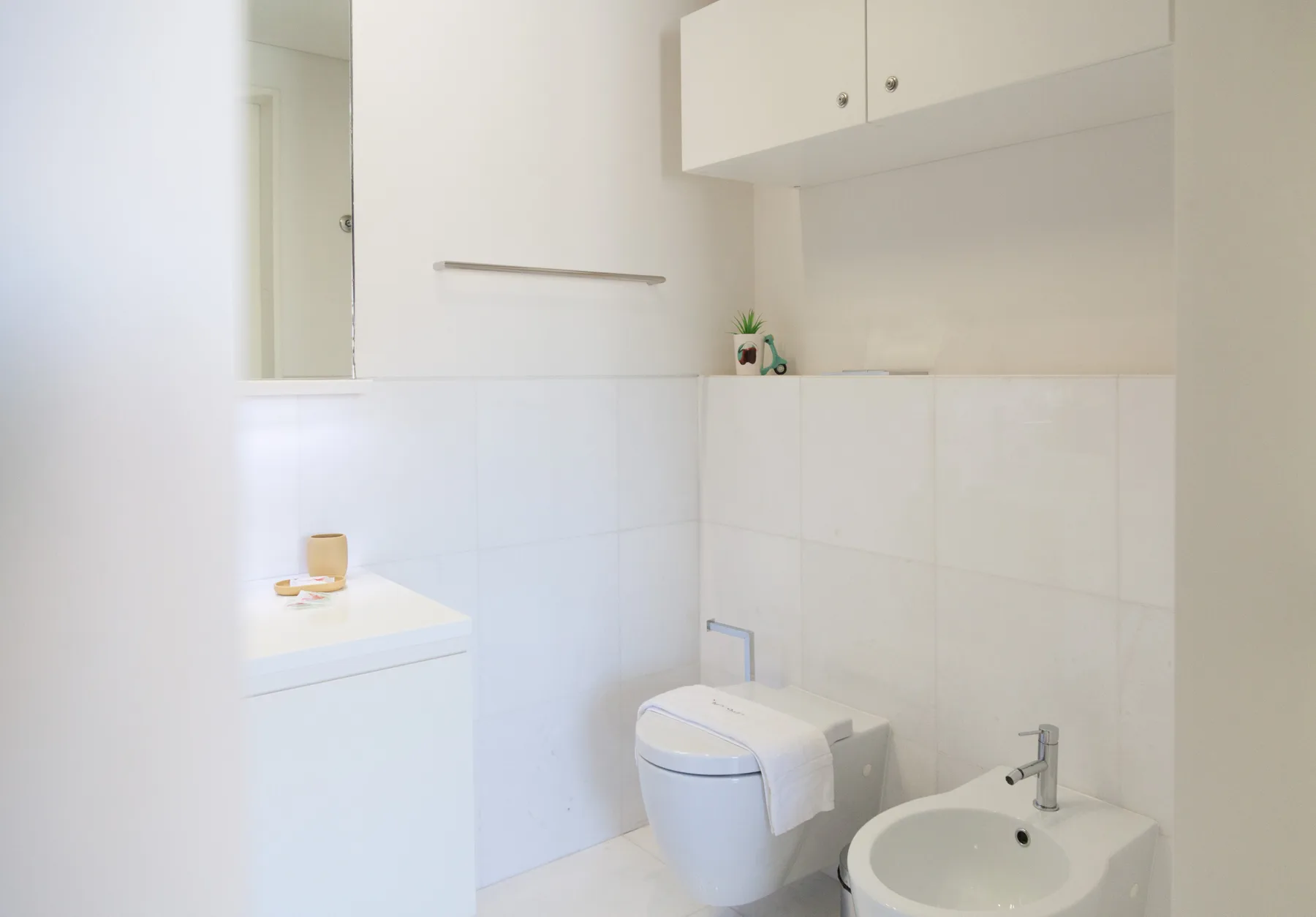 Un baño luminoso con un inodoro y un bidé.