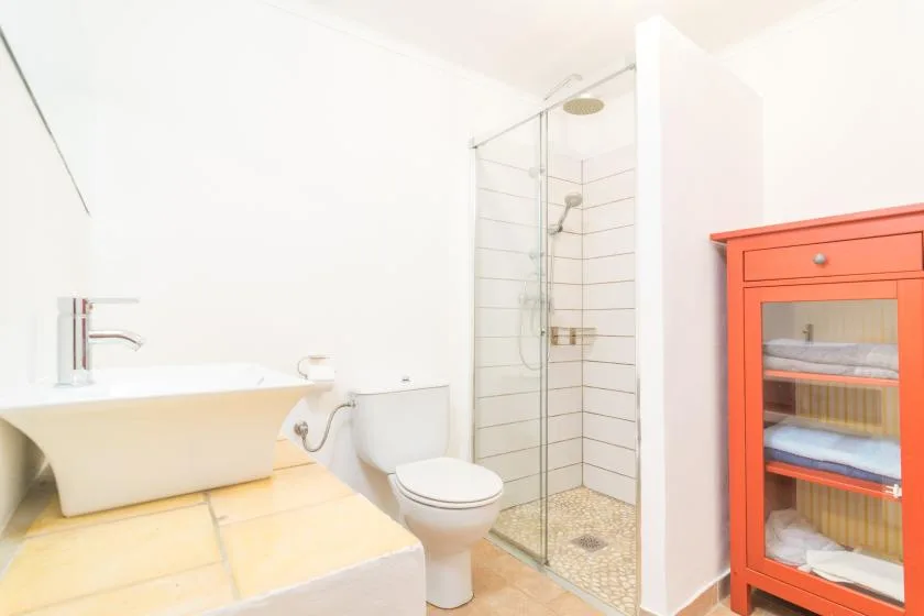 A bright bathroom with a bathtub, toilet, and glass shower.