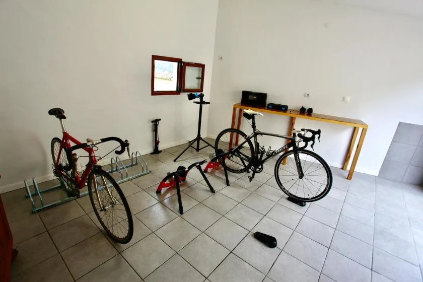 A bicycle storage area with several bicycles and a worktable.