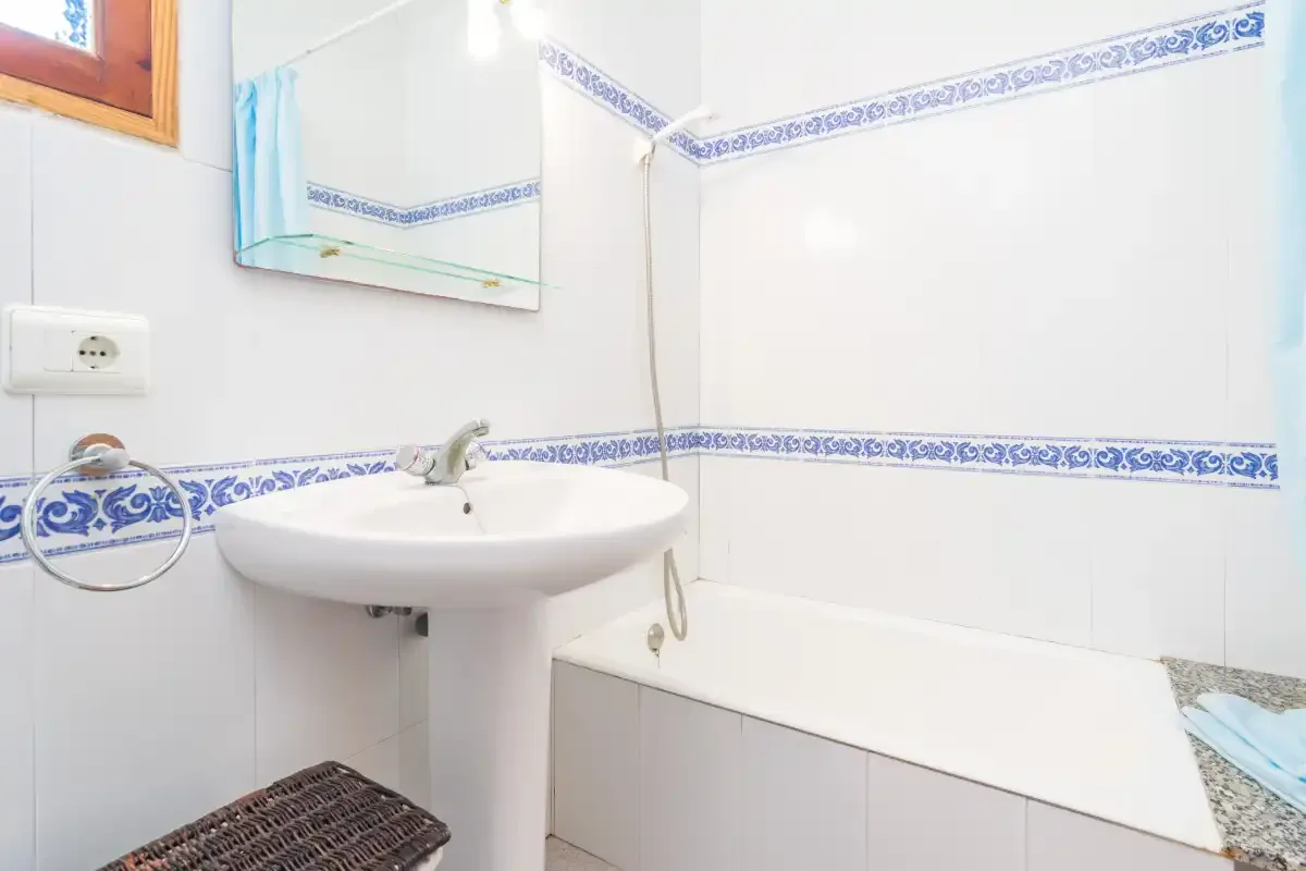 A tiled bathroom with a sink and bathtub.