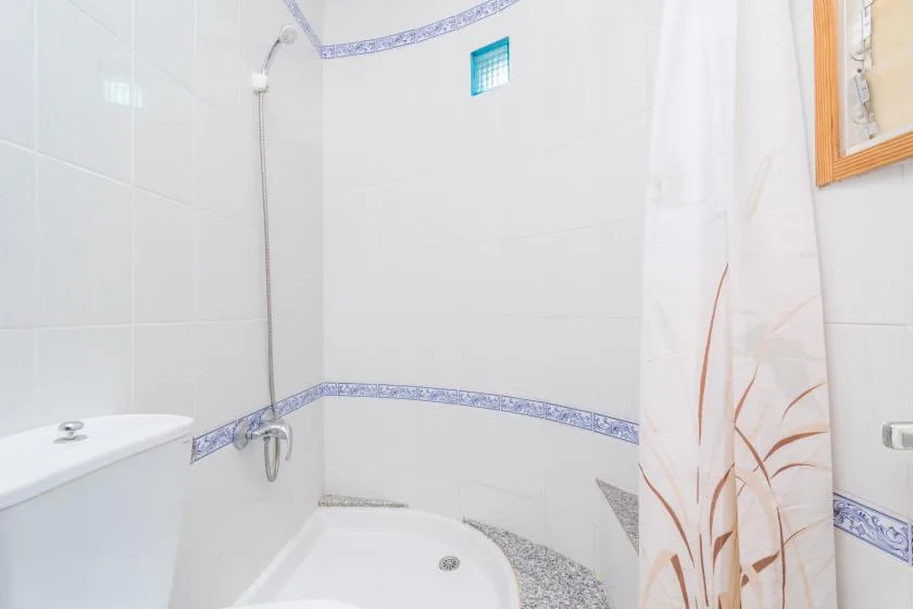 A tiled bathroom with a bathtub and a patterned shower curtain.
