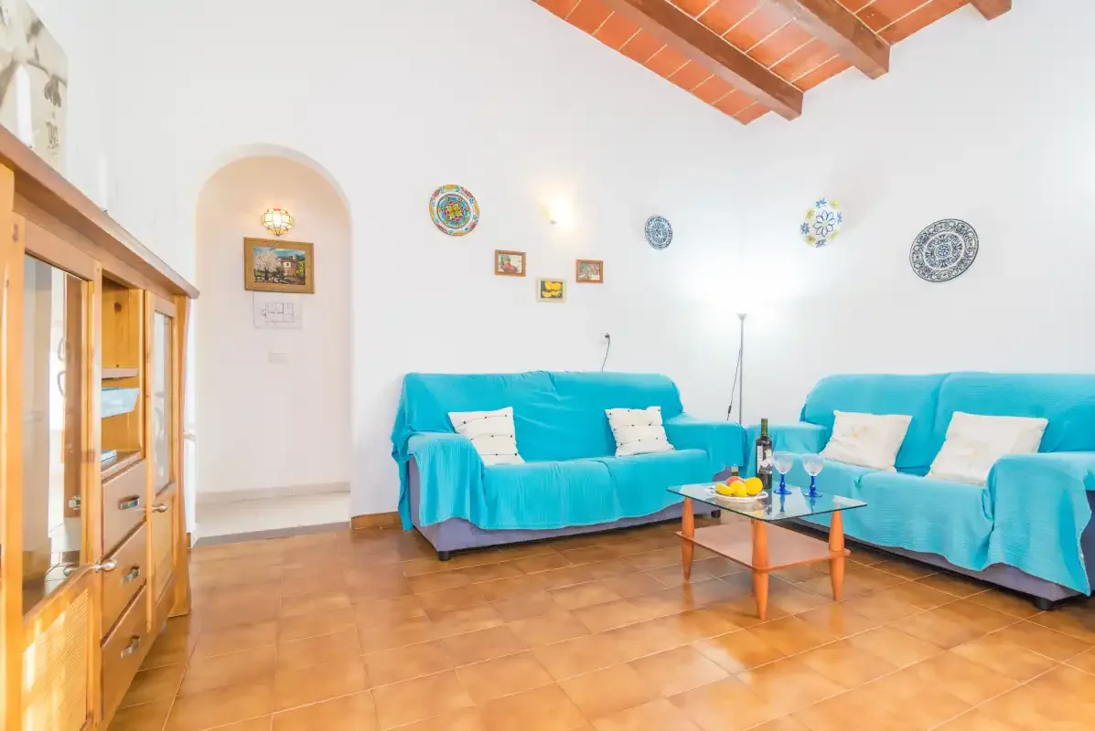 A living room with turquoise-covered seating and a low coffee table.
