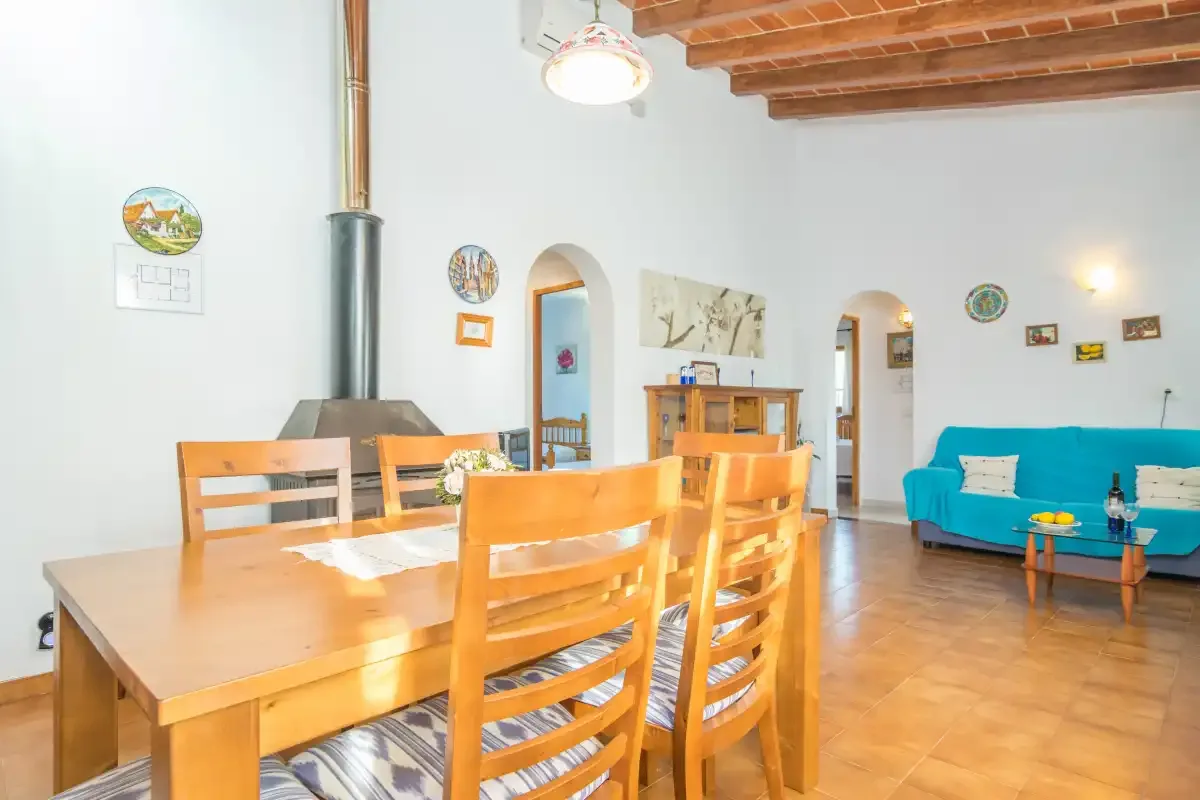 A dining and living room with a wooden table and turquoise seating.