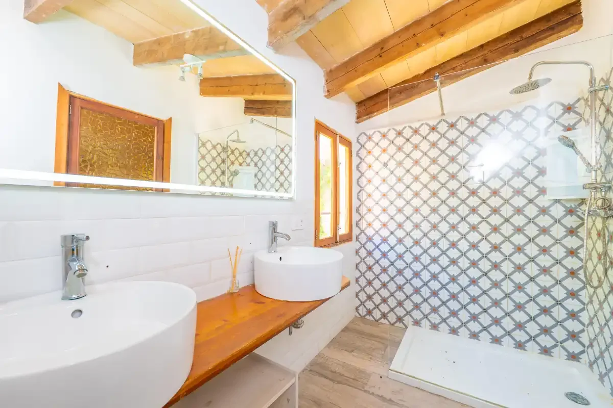 A bathroom with a long sink counter and a walk-in shower.