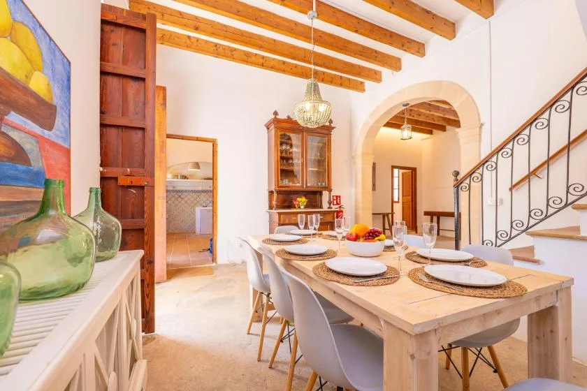 A dining area with a long table set with plates and chairs.