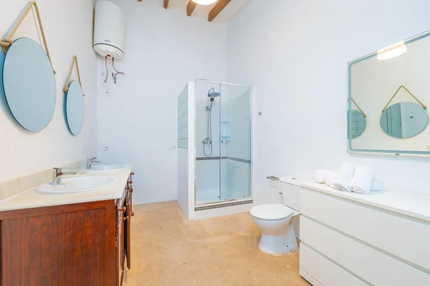 A bright bathroom with a glass shower, sink, and white cabinetry.