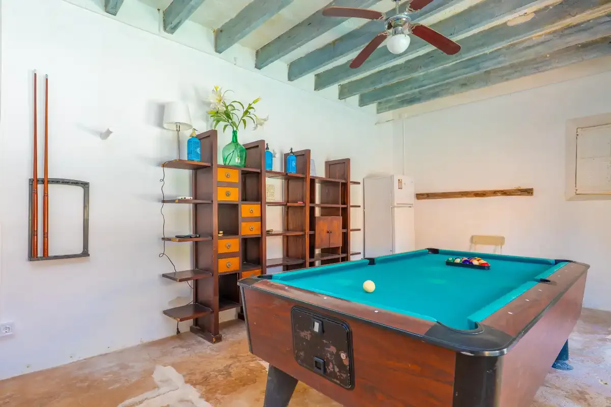 A game room with a pool table and open shelving.