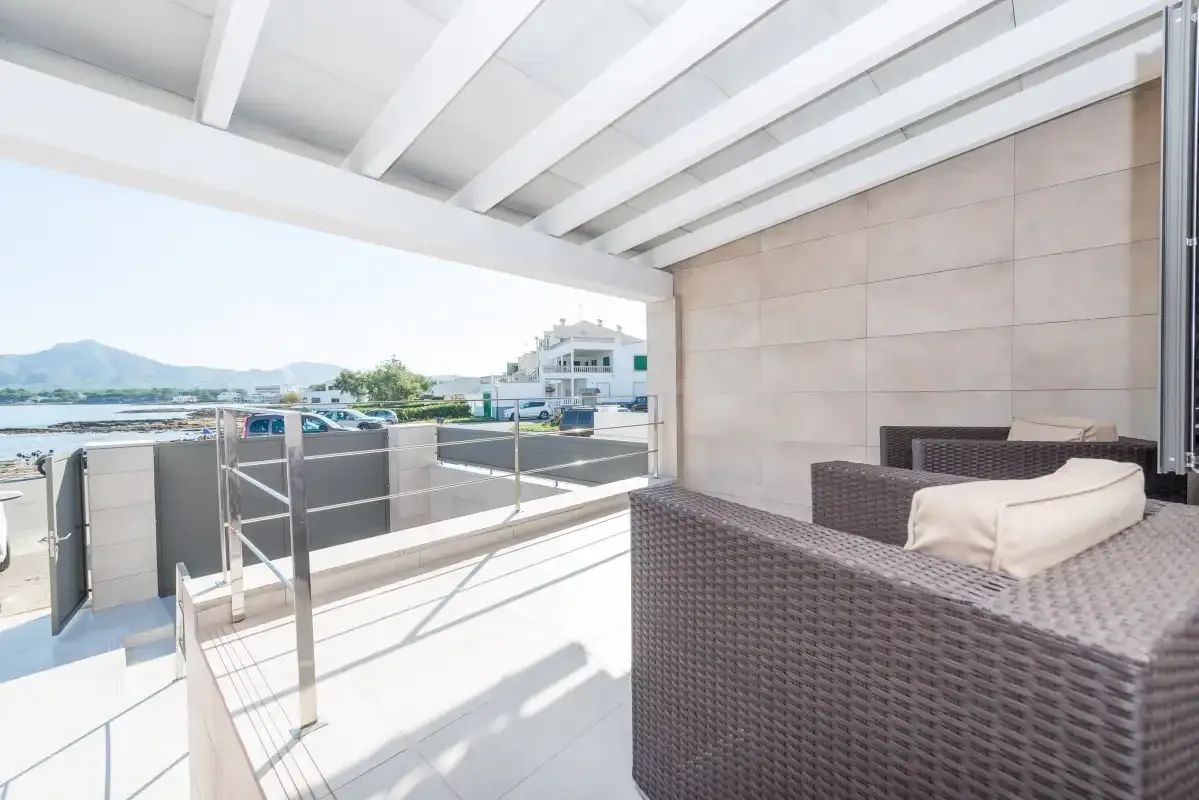 A covered outdoor seating area overlooks nearby buildings and distant hills.