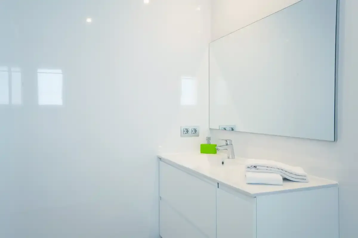 A bright bathroom vanity with a sink and large wall mirror.