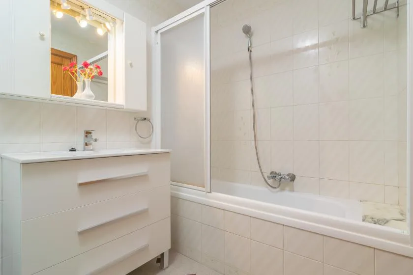 A tiled bathroom with a bathtub, shower, and vanity.