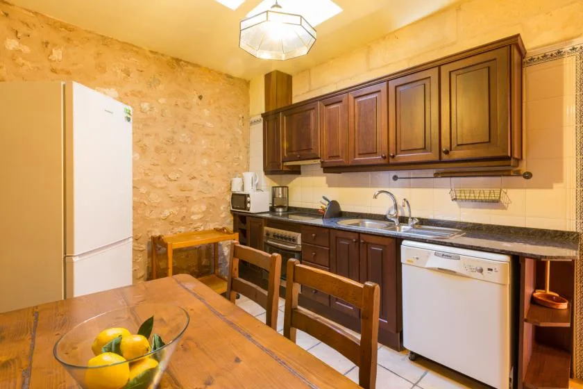 A kitchen with dark wood cabinets, a sink, and a dining table.