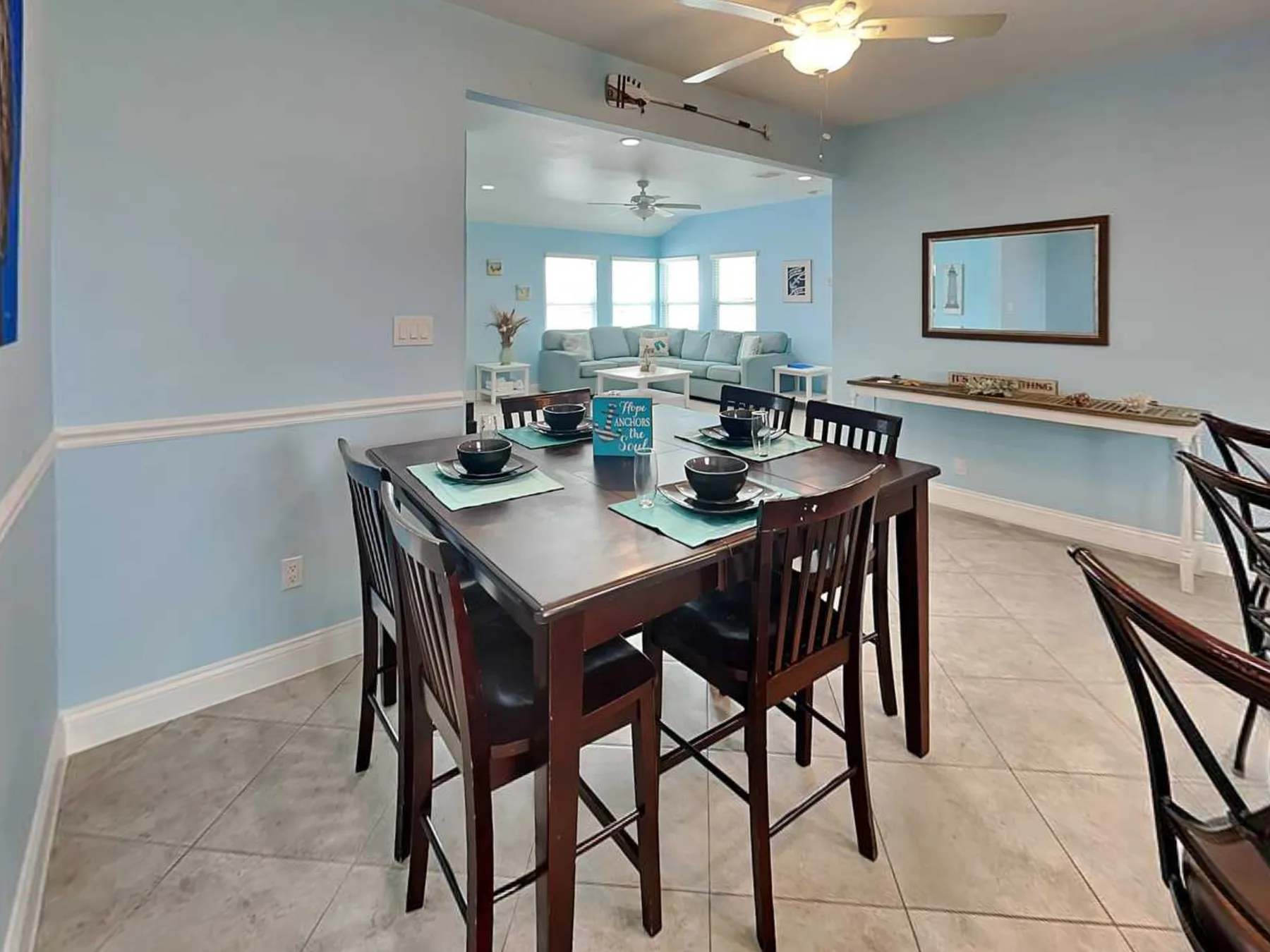 A dining area with a set table opens onto a bright living room.