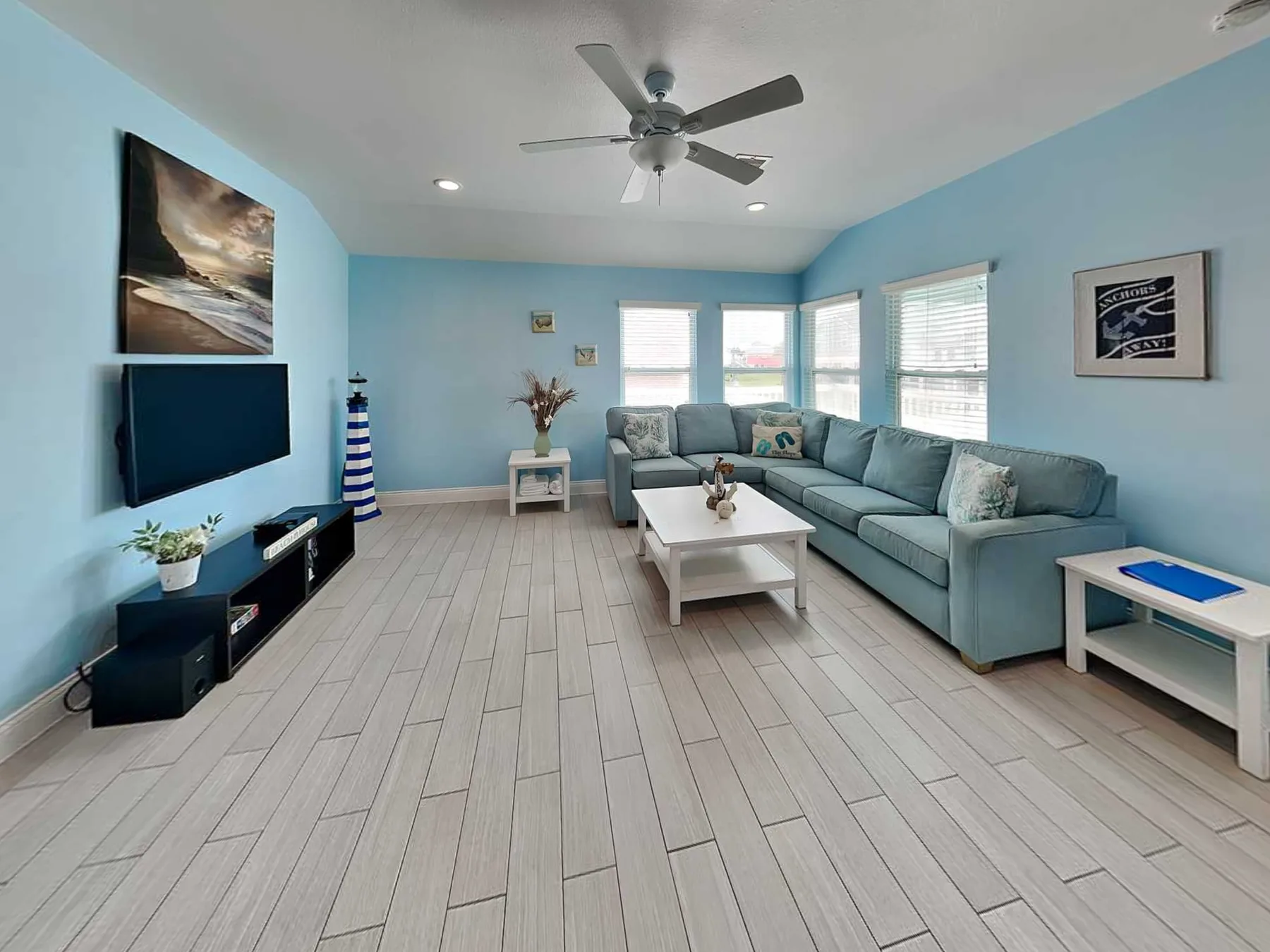 A bright living room with blue walls, seating, and a coffee table.