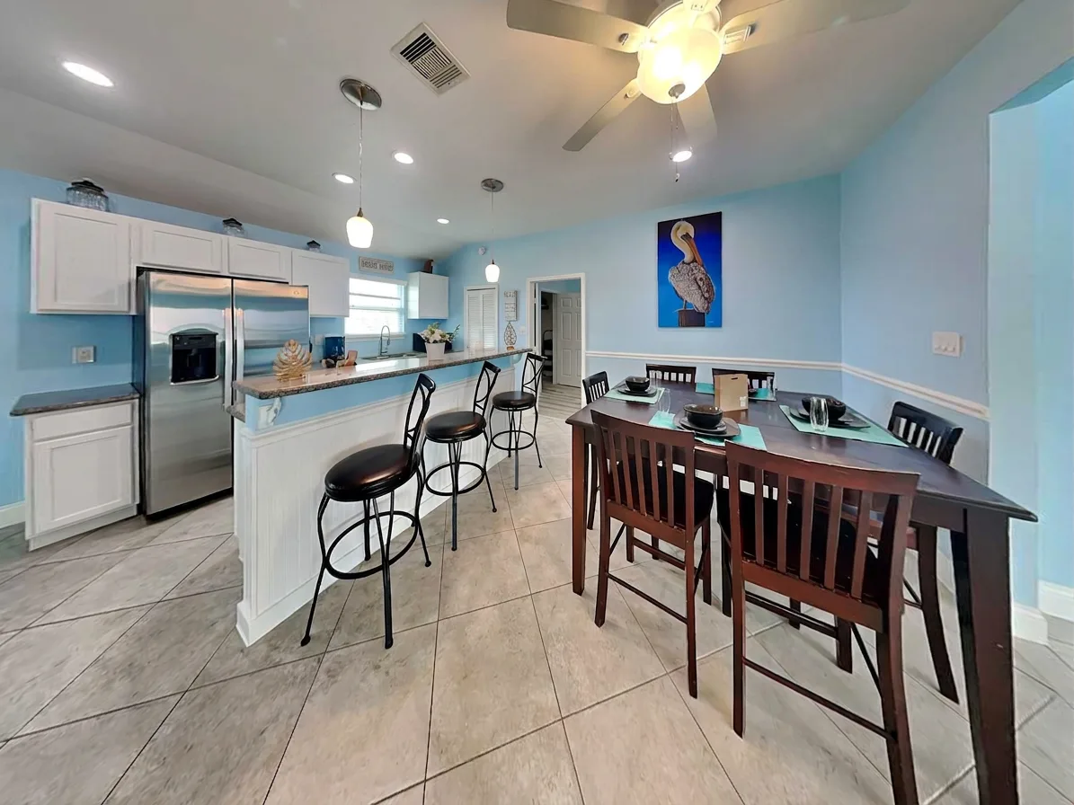 A bright kitchen and dining area with a breakfast counter and dining table.