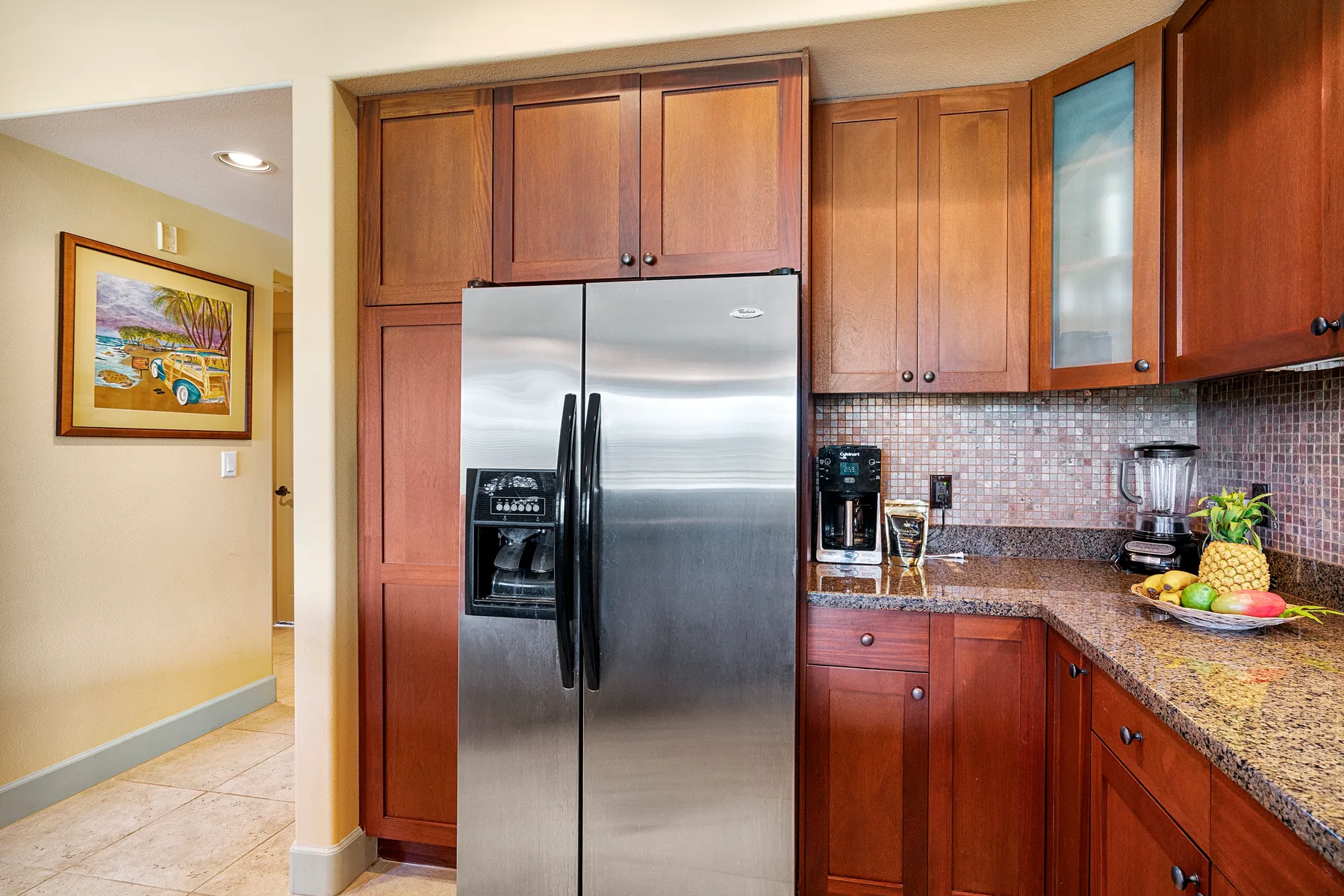 Una cocina con gabinetes de madera, un refrigerador de acero inoxidable y una encimera.