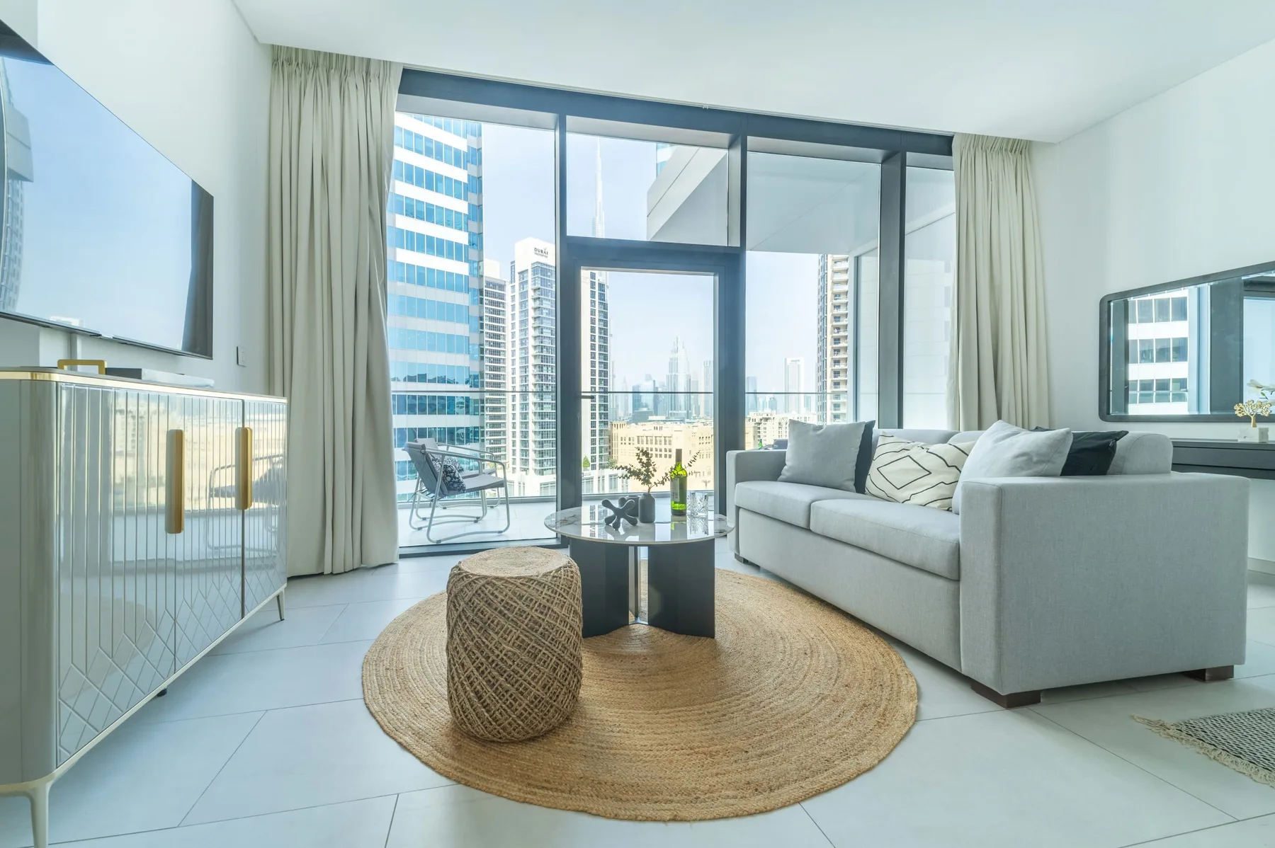 Una sala luminosa con asientos junto a grandes ventanas con vistas a edificios de la ciudad.