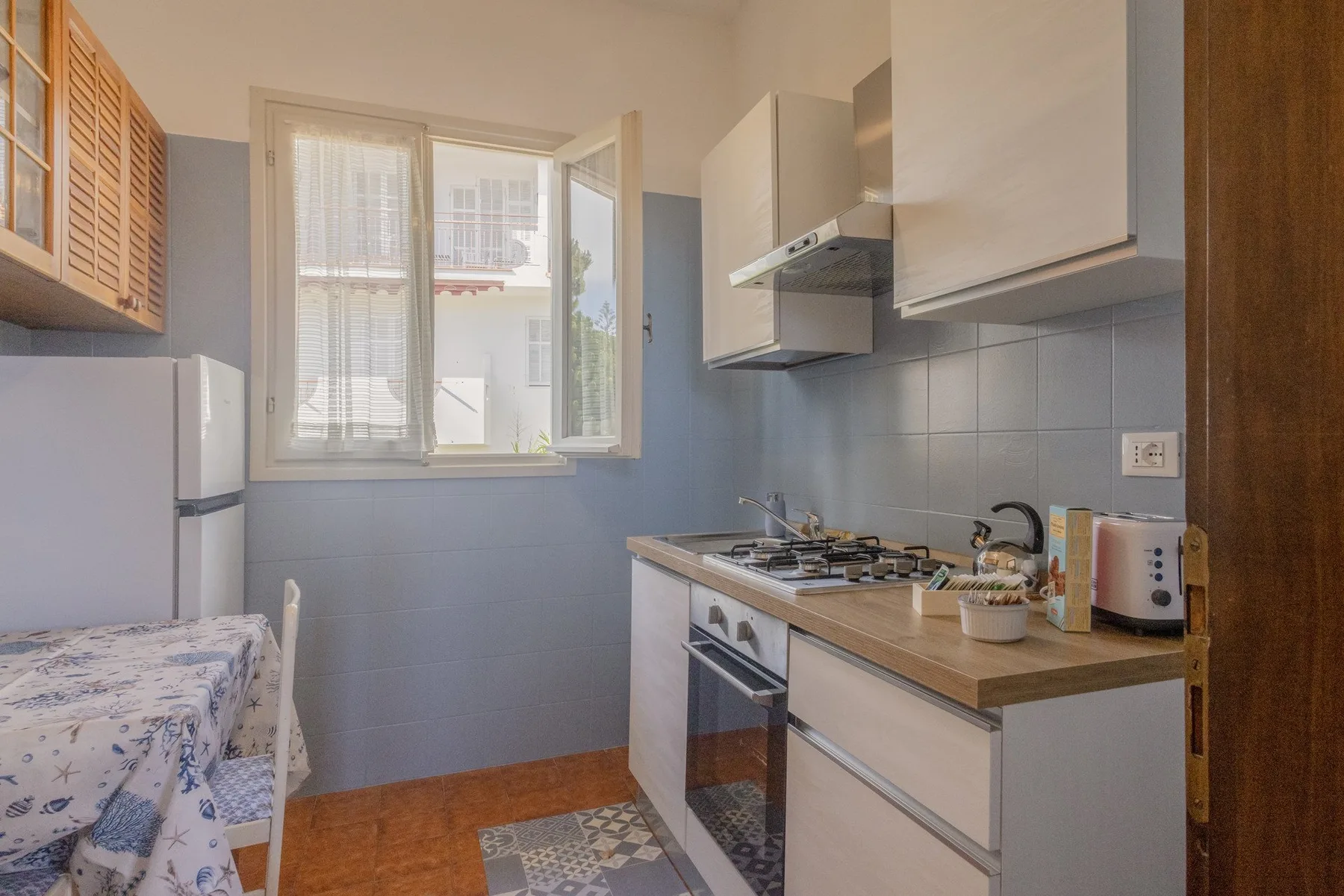 A compact kitchen with a countertop and a window overlooking nearby buildings.