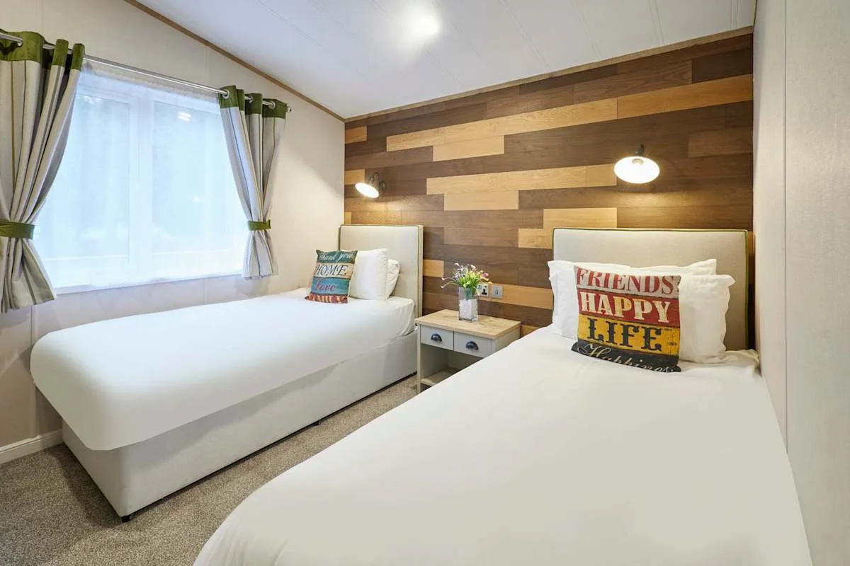 Un dormitorio con dos camas y una pared decorativa de madera.