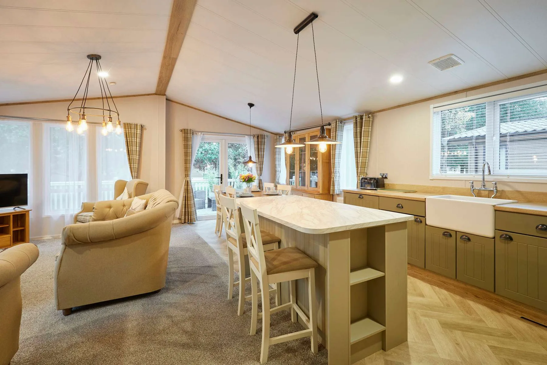 Una sala de estar y cocina de planta abierta con una gran isla y asientos para comer.