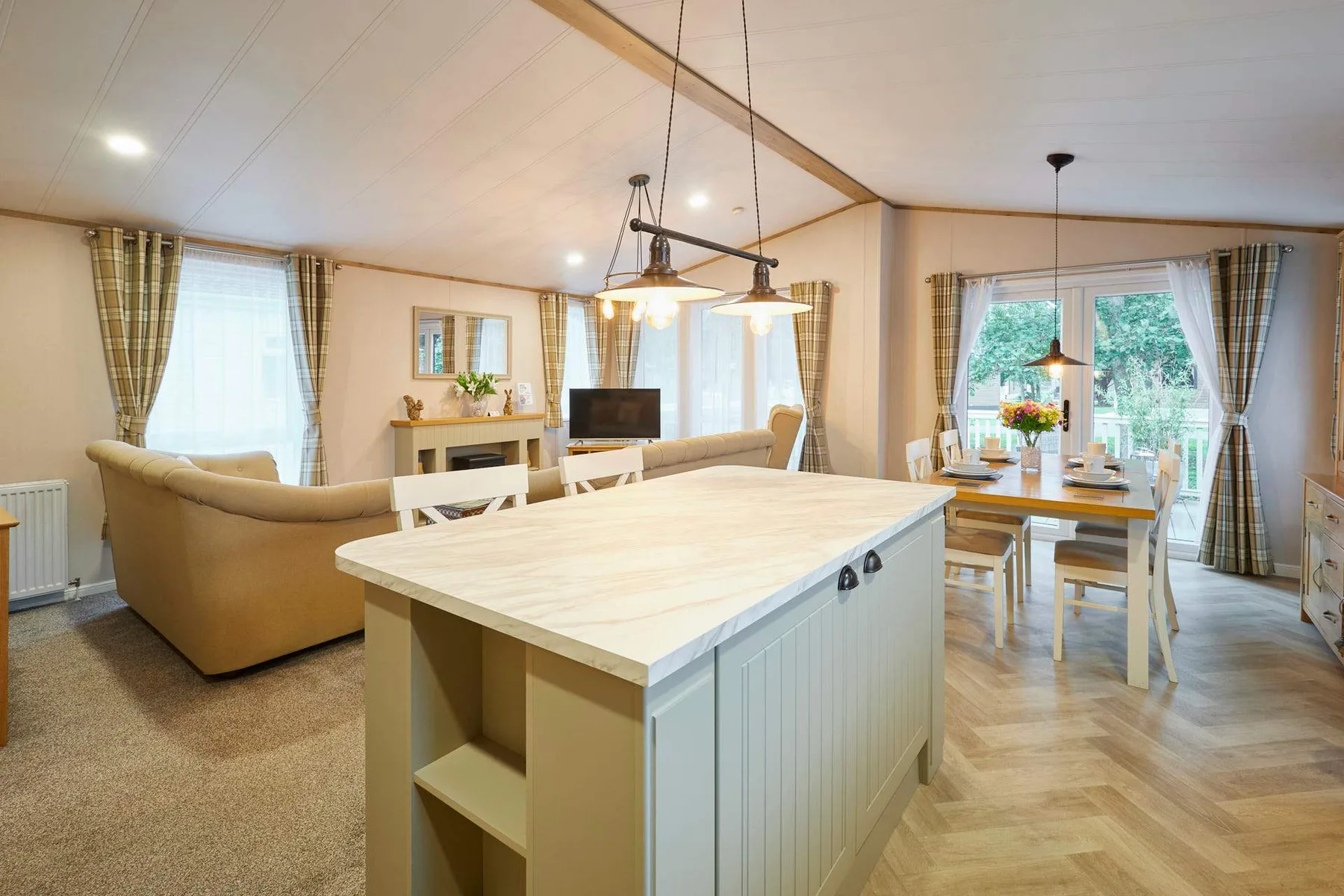 Una sala-comedor de planta abierta con una isla de cocina y una mesa.
