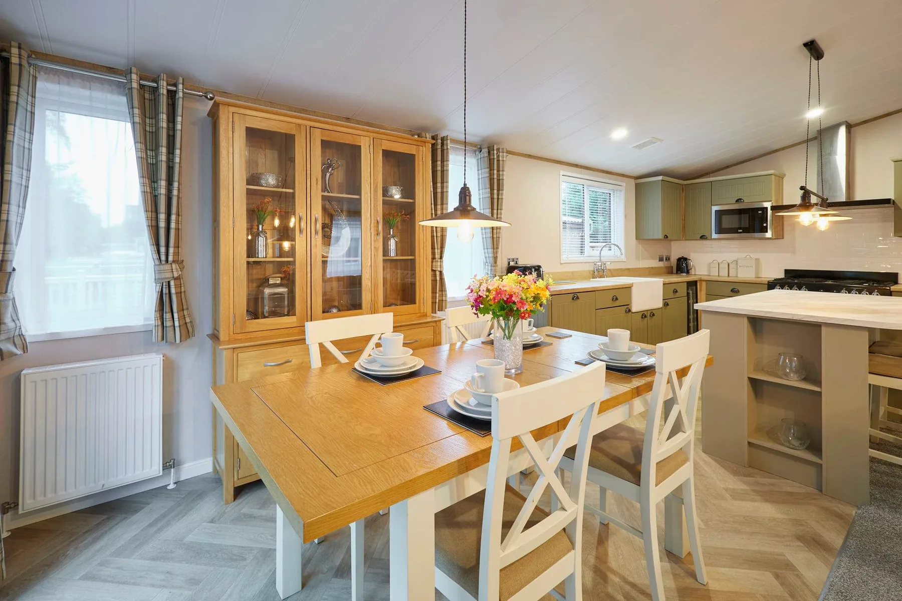 A bright kitchen and dining area with a wooden table set near the counters.